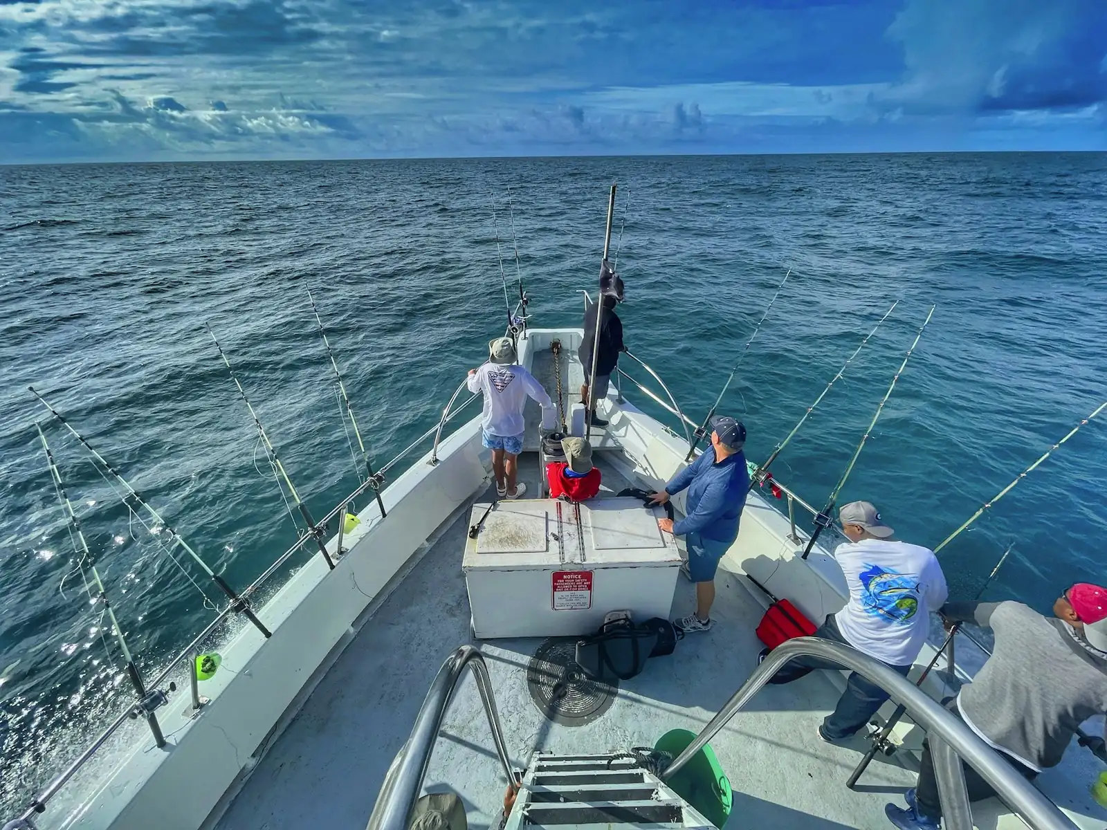Crew on the bow of a fishing boat heading offshore